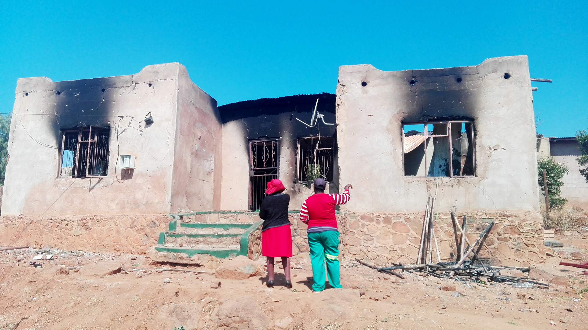 Angry mob burns down car and house